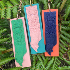 Tania Tupu Kōkako NZ Bird Pendant, Te Kōkako is wearing a kakahu ribbonwood flora laced with a taniko border