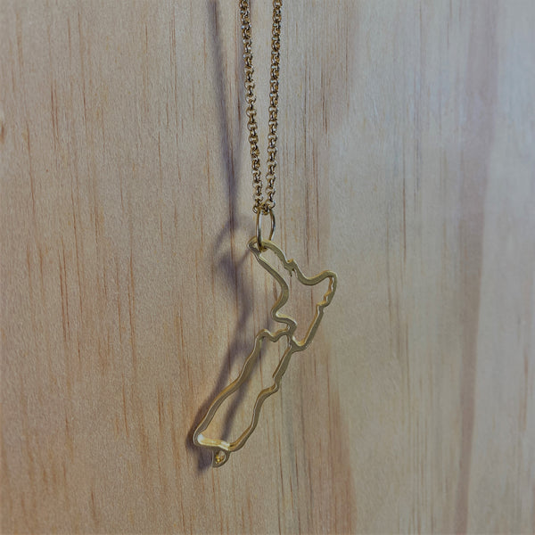 ﻿This one is for all, wear it proudly at home or away.   Not too shiny with a soft finished matched with at 50cm gold stainless chain.   Zinc alloy, electroplated soft matte gold.  Map size 60 mm (L) x 12-25 mm (W) Limited run of these made before lockdown, originally designed in 2007 as part of Tania Tupu's 'Return to Paradise' sterling silver collection. Made with Aroha in Aotearoa