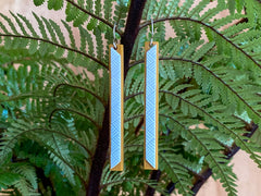 Newly launched design March 2020 Wearable handcrafted 3-dimensional lengthy resin stick bead. The principal goddess of Te Whare Pora is Hineteiwaiwa, who represents the arts pursued by women and is also the goddess of childbirth.  Te Whare Pora a special building reserved for weaving. A place traditionally where weavers would receive knowledge of the arts of weaving through karakia.  60 mm (L) x 5 mm (W) x 4 mm (D) two-toned 3-dimensional weave design.