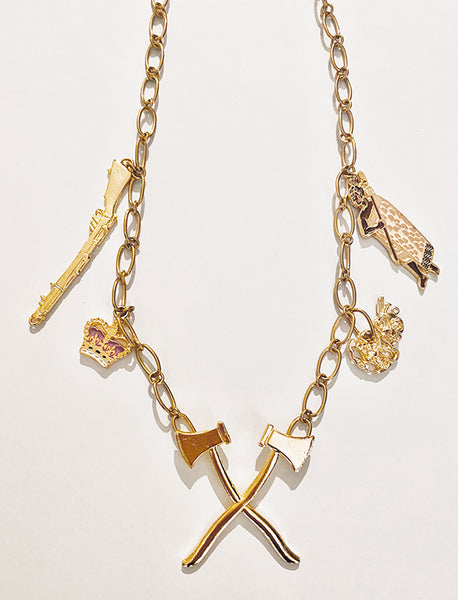 This necklace with carefully selected components tells a story. Maori who suffered from land confiscation and fought against the crown were not keen to enlist in the First World War.   Pioneer Axe (WW1) Anchoring the chain. Supported by a tiki and warrior vs crown and musket. Zinc alloy, electroplated gold, and handpainted enamel charms. Made in Aotearoa Chain Length: Long 55cm oval belcher stainless gold chain. A standout, center of attention design patriotic to Aotearoa