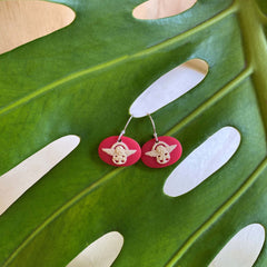 Inspired by the Tiki who came down from the stars to create the first woman so I put wings on him so he can land safely.  A design that has been around since I first starting designing way back back.   A true NZ icon earring size of 18mm (W) x 12mm (H) Wearable handcrafted 3-dimensional NZ artwork on sterling silver hooks. Available in fire red or olive green. 