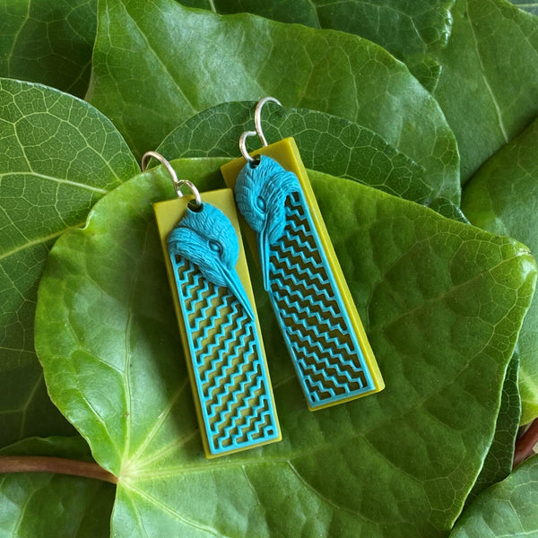 Tania Tupu's handmade earrings of the Kingfisher wearing a poutama cloak. This bird is known to perch in prominent places with a calm, patient, and watchful nature. Here in New Zealand our native Kingfisher is known by its Maori name kōtare. 