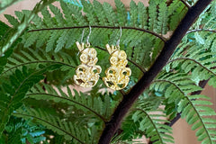 Designed and created in 2006 as part of Tania's flying tiki cameo range, this iconic pair of earrings has lasted the test of time.  Originally cast in bright resin colours in the early days, fast-forward to zinc alloy electroplate finish available today. Zinc alloy, electroplated finished (Antique brass, Matte Black and Gold Plate) 3-dimensional 25 mm Tiki NZ icon on sterling silver hooks.  Believed to bring good luck and keep evil spirits away. Representing fertility, loyalty, and strength of character. 