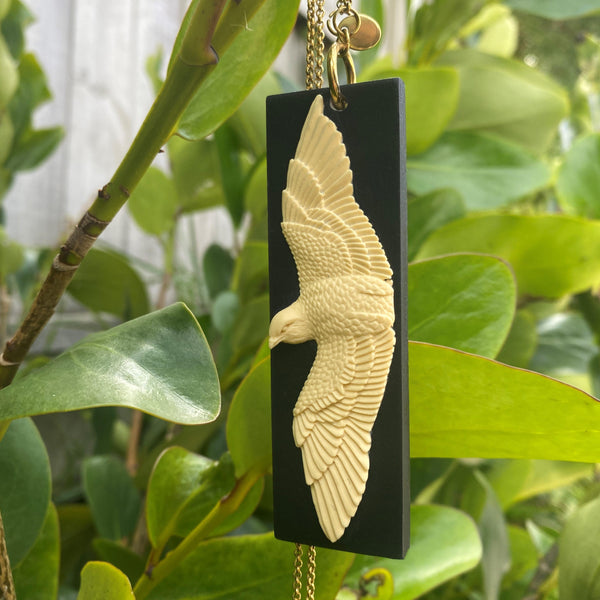 Tania Tupu, Inspired by the need for change, to be fearless, versatile and adaptable like the kārearea A statement pendant piece featuring our kārearea layered on a mustard base.  Proudly handcrafted 3-dimensional NZ artworks suspended on a long stainless steel chain. 
